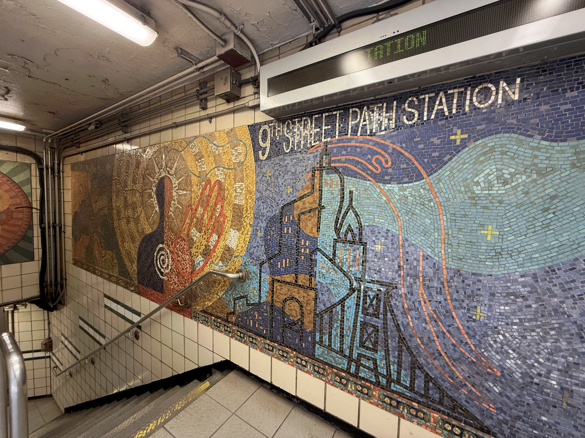 Mosaic of 9th Street PATH Station depicting abstract figures, stars and clouds.